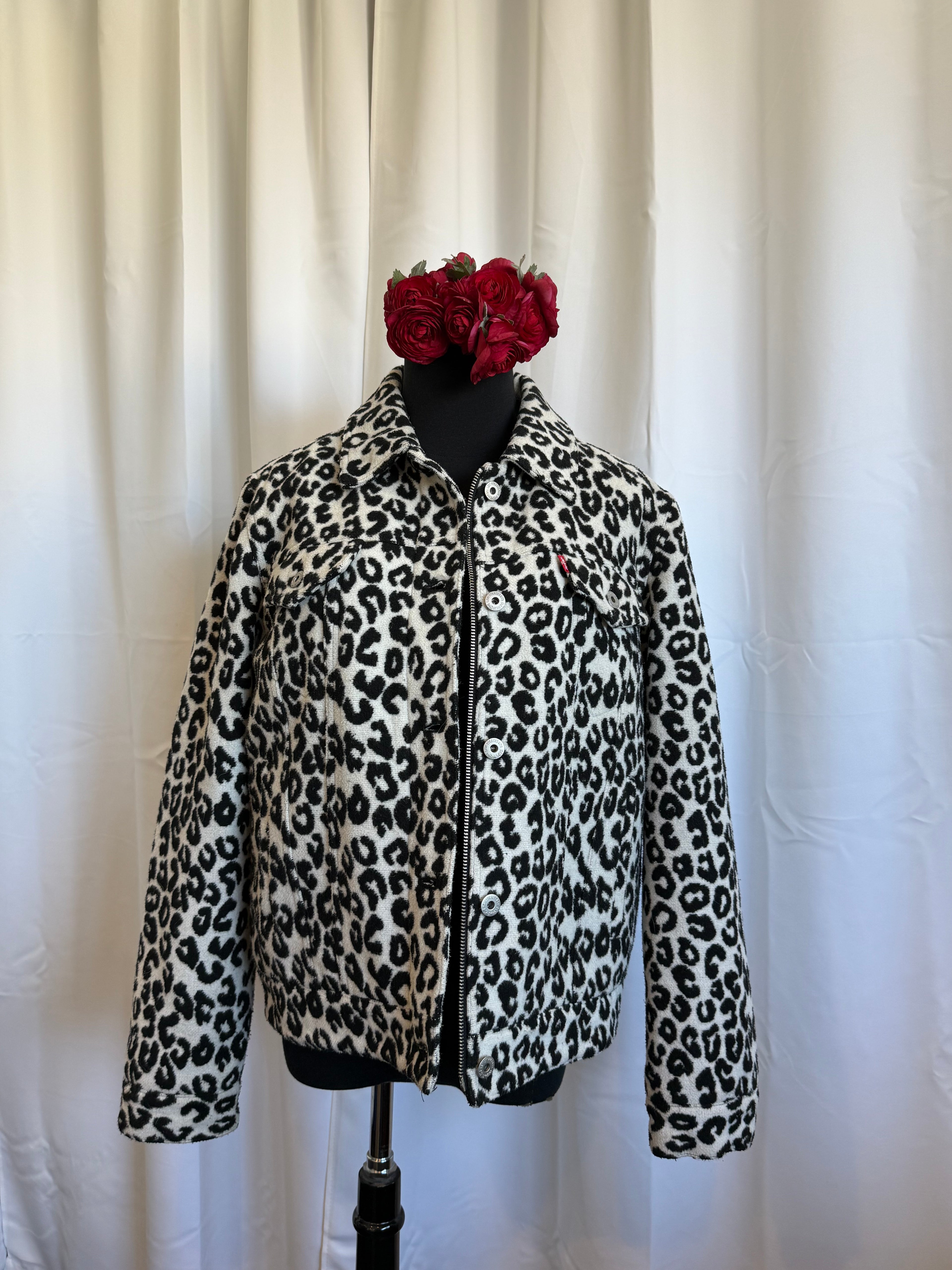 Leopard print jacket on a form with a red flower on a white background