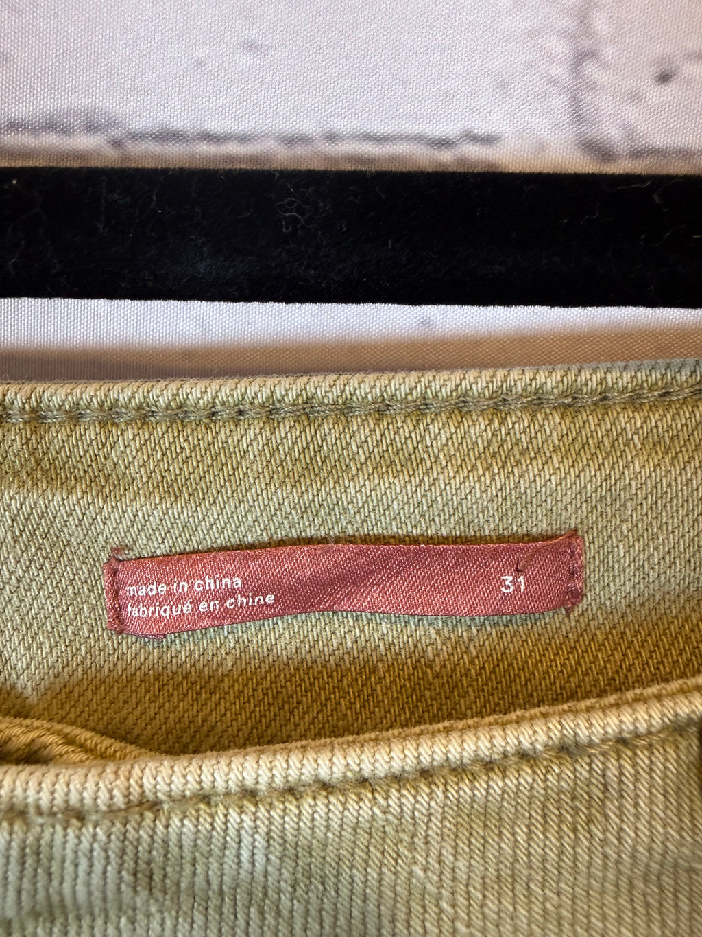 Close-up of a fabric tag on a textured beige background