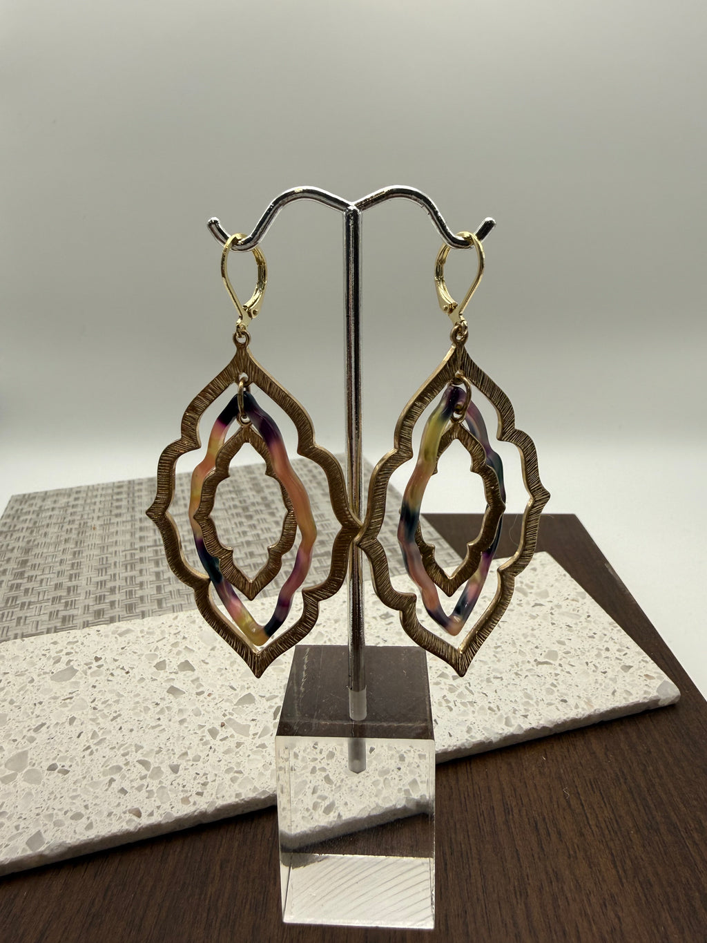 layered gold and black/tan acrylic earrings in an organic diamond shape
