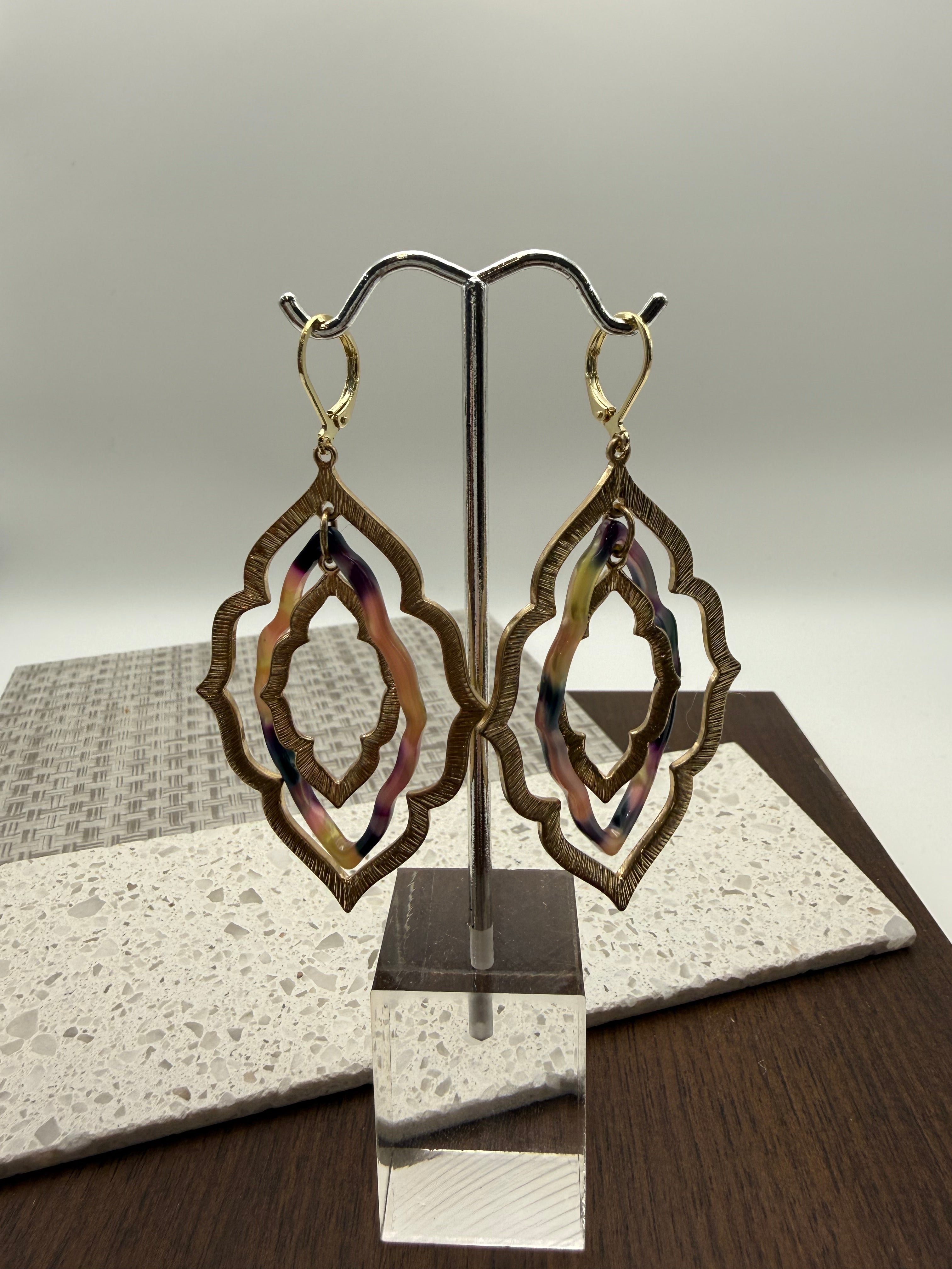 layered gold and black/tan acrylic earrings in an organic diamond shape