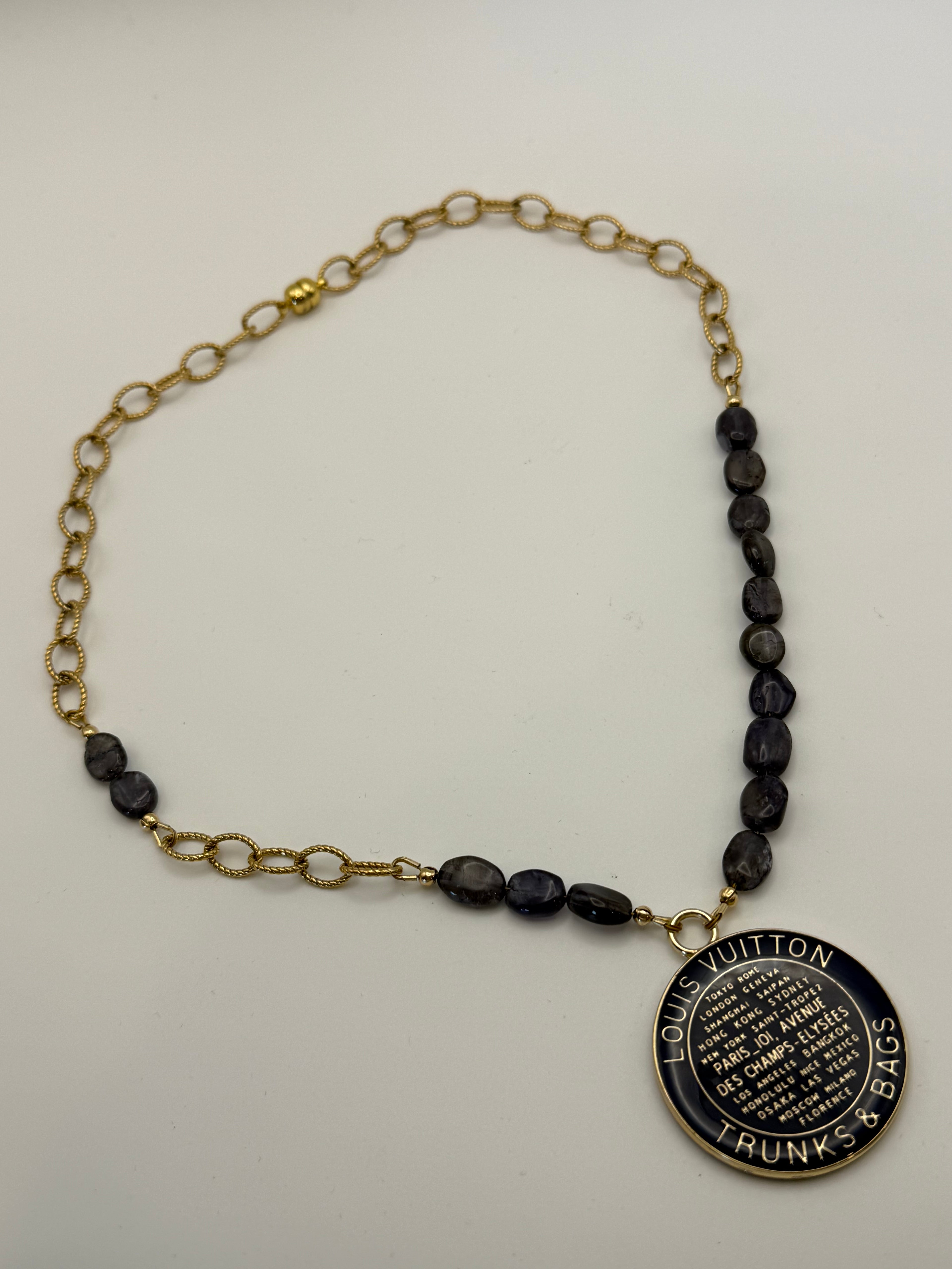 Necklace with blue beads and a gold chain on a white background