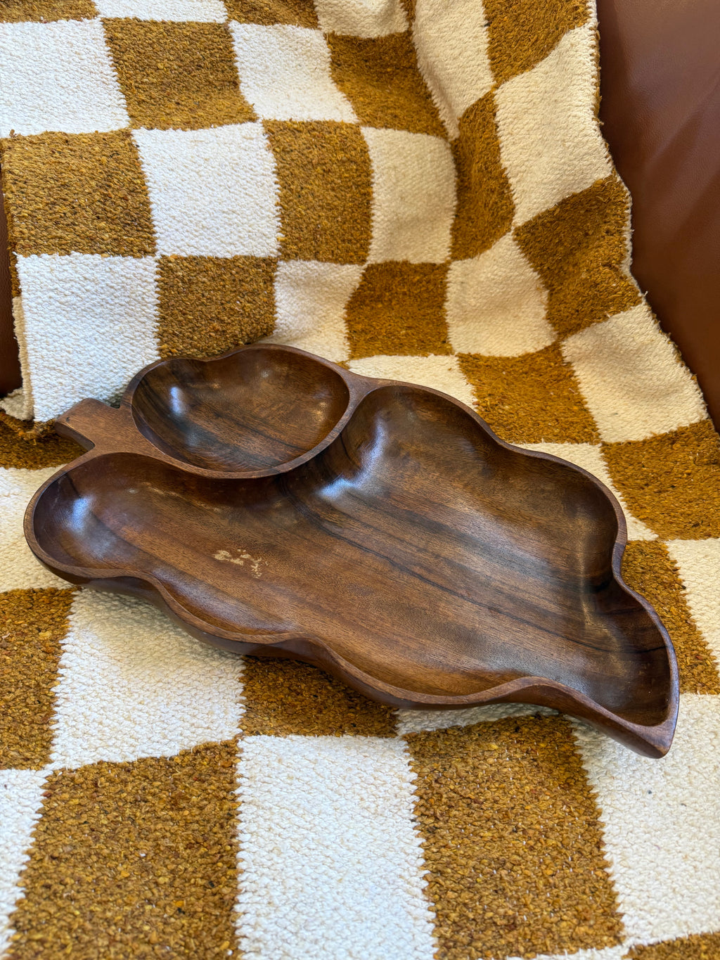 Wooden leaf-shaped tray on a checkered fabric background