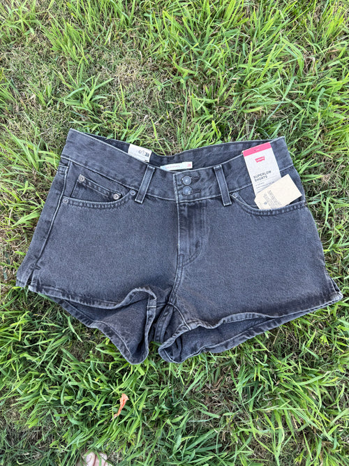 Black denim shorts with Levi's tags on a grassy background